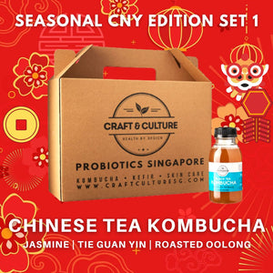 Craft & Culture's promotional image for the Chinese Tea Series - The Classics - Kombucha Set 1 features a cardboard box and a bottle of kombucha in Jasmine Green Tea, Tie Kuan Yin, and Roasted Oolong flavors amid red and gold festive decorations.