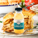 A bottle of [FINAL] Apple Pie Black Tea Kombucha by Craft & Culture - Kombucha, Kefir & Probiotics Singapore sits appealingly next to apple pie, its crust hugging tender slices. An apple and bowl accent the scene. This kombucha, rich in probiotics, perfectly complements the dessert.